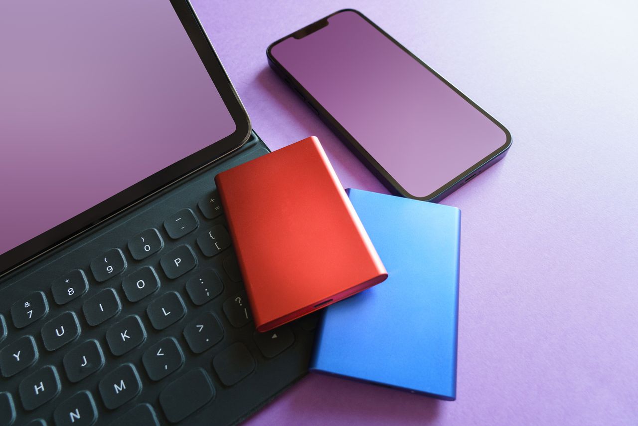 The Art of Drawing Readers In: Your attractive post title goes here Colorful gadgets including a smartphone, tablet, and SSD on a purple background, ideal for tech-themed projects.
