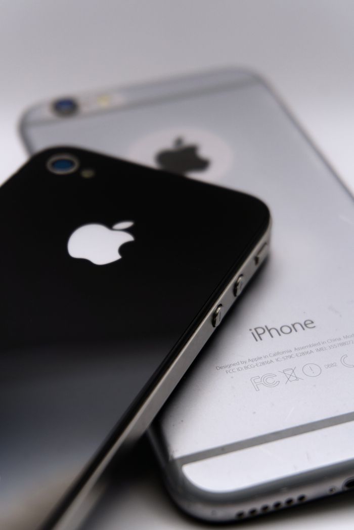 Detailed shot of two smartphones featuring the Apple logo, showcasing modern technology design.